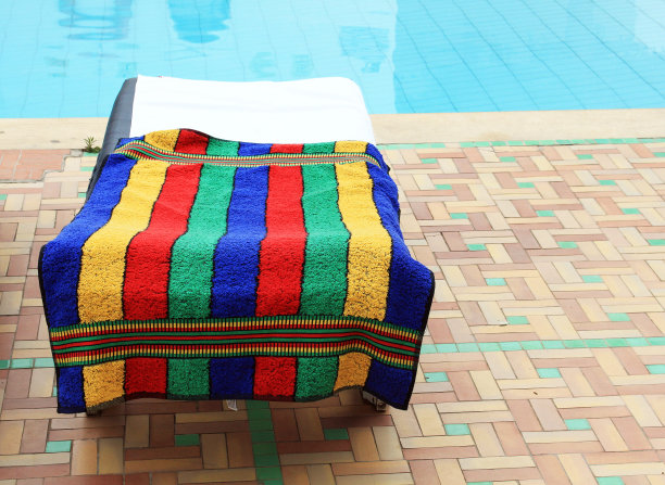 用毛巾放松游泳池附近的椅子图片下载