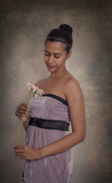 一个年轻的印度女人拿着一朵花图片下载