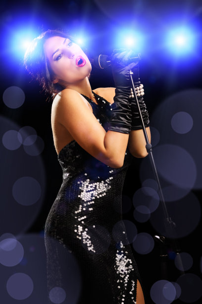 美丽的年轻女歌手在舞台上唱歌图片下载