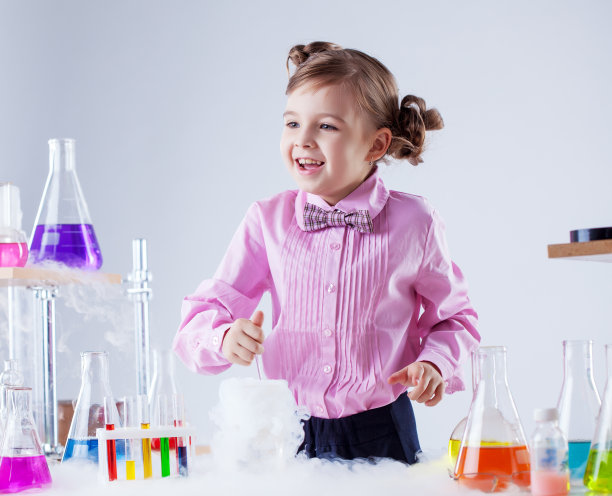 快乐的小女孩摆着各种各样的烧瓶图片下载