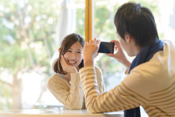 年轻夫妇用智能手机拍照图片下载