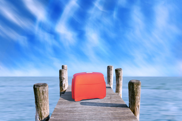 红色行李箱停在码头上图片下载