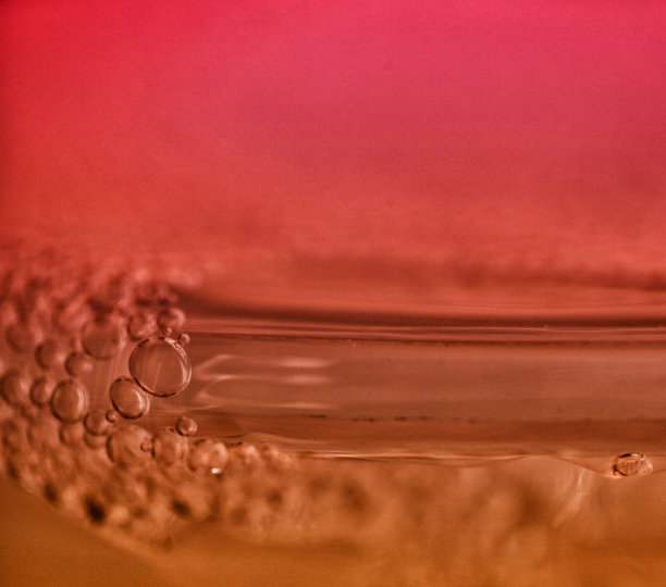 橙色背景下的水特写镜头图片下载