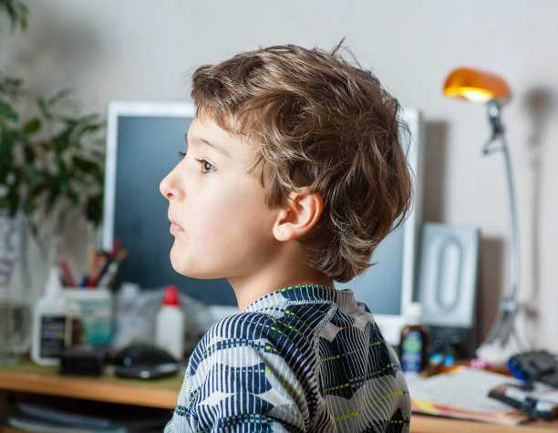 小男孩坐在桌子旁的侧视图图片下载