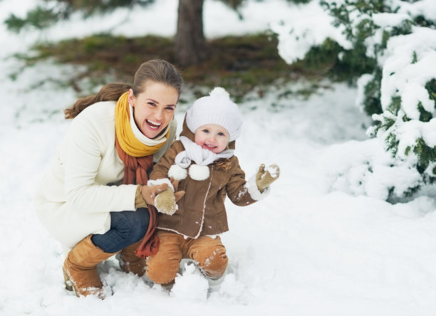 快乐的妈妈和宝宝在冬季公园的肖像图片下载