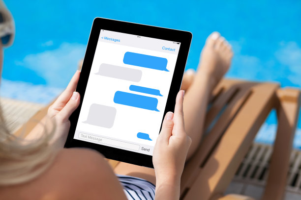 女孩躺在游泳池旁的躺椅上，拿着平板电脑图片下载