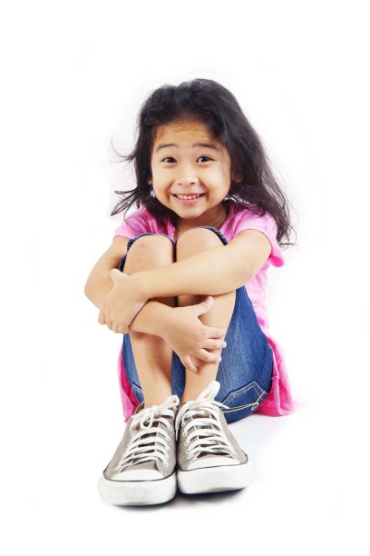 穿着牛仔裤坐在地板上的漂亮小女孩图片下载