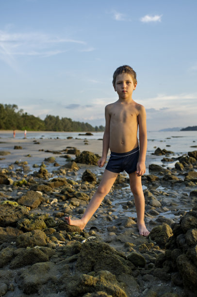 岩石海滩上的小男孩图片下载