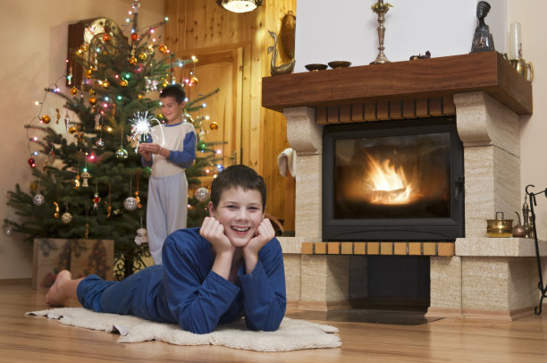 圣诞节时，两个年轻人站在壁炉前图片下载