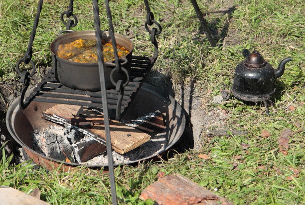 篝火上放着一壶一锅的汤图片下载