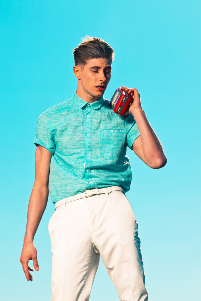 五十年代复古的穿着蓝色衬衫的时尚男士在听收音机。图片下载