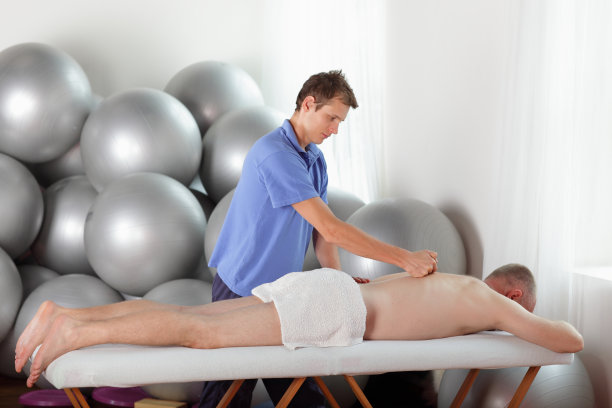 男性治疗师按摩中年白人男子的背部图片下载