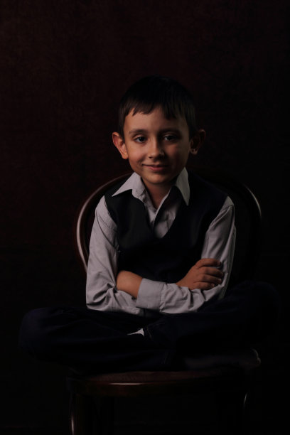 快乐的男孩坐在椅子上图片下载