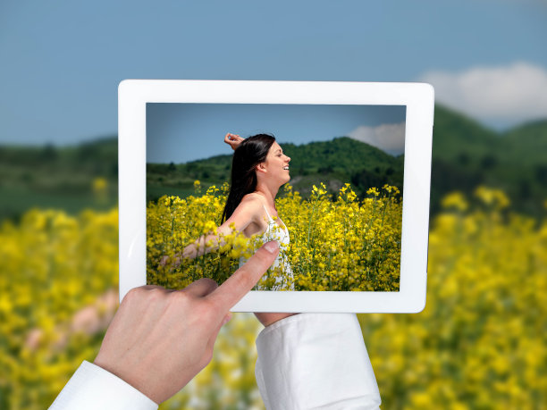 平板和女孩在满是鲜花的草地上图片下载