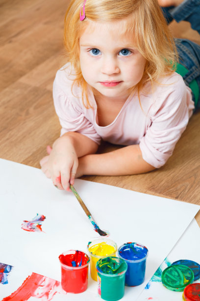 可爱的红发小女孩拿着刷子看着相机图片下载