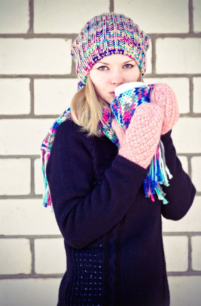 拿着咖啡杯的年轻女人冬天的时候图片下载