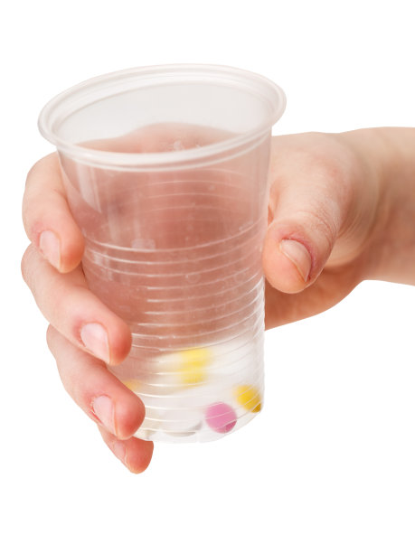 塑料杯，手里放一份药片图片下载