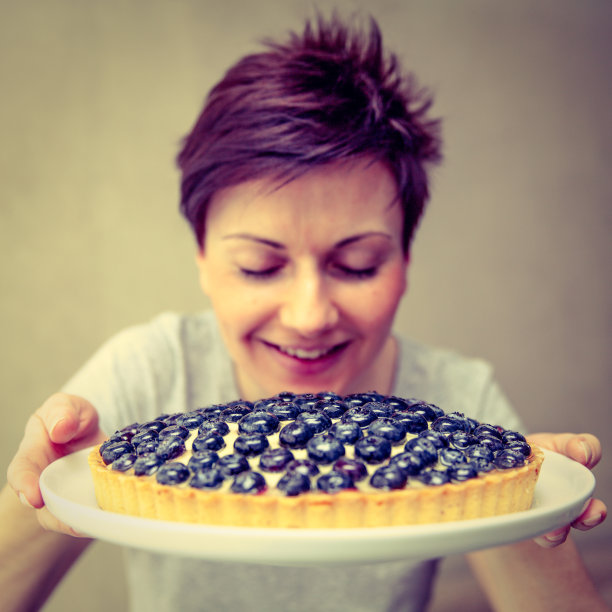 年轻女子期待着蓝莓馅饼的味道图片下载