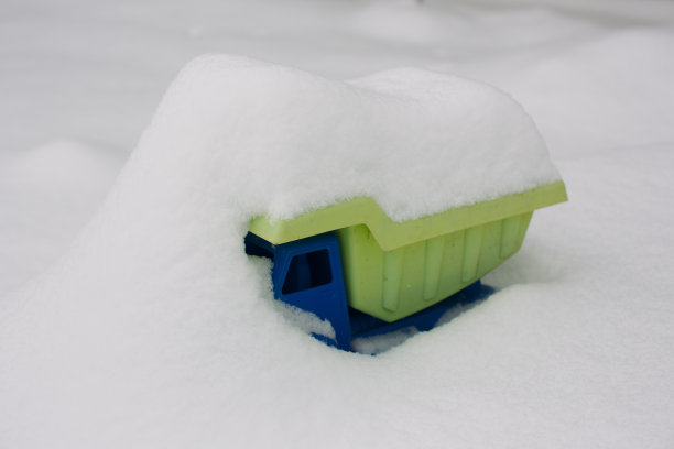 被雪覆盖的玩具倾卸卡车图片下载