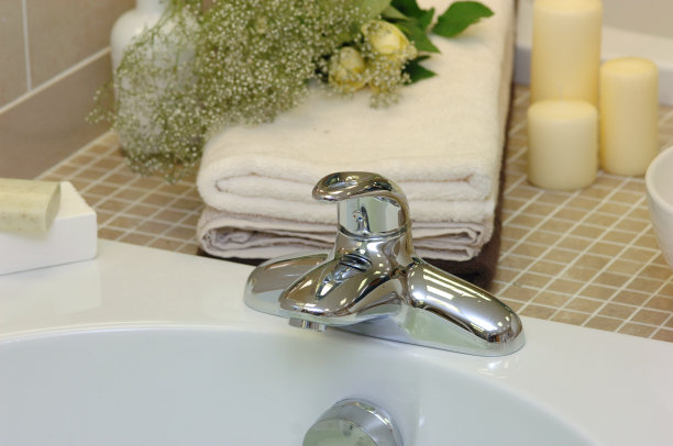 浴室水龙头与毛巾、肥皂和鲜花的照片图片下载