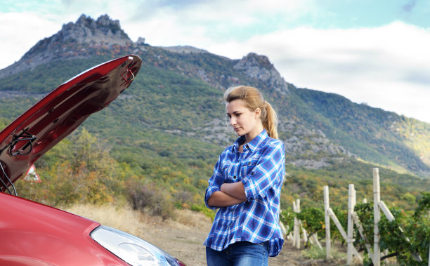 年轻女子靠近破车图片下载