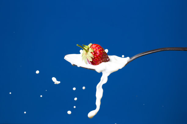 草莓落入牛奶的高速照片图片下载