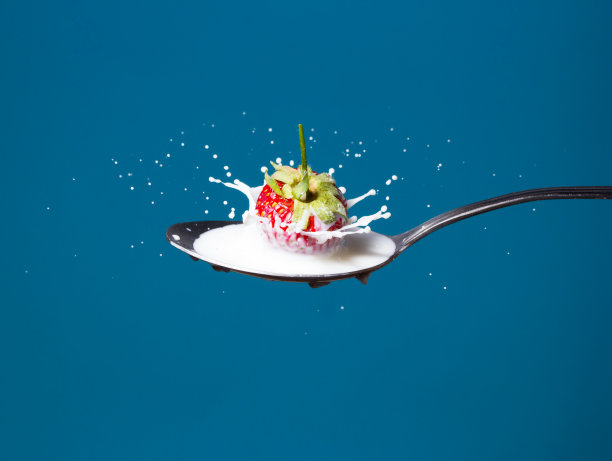 草莓落入牛奶的高速照片图片下载