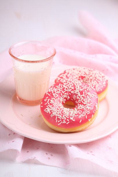 有粉色糖霜和牛奶的甜甜甜圈图片下载