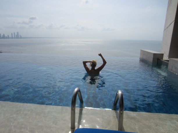 在俯瞰大海的游泳池里的女人图片下载