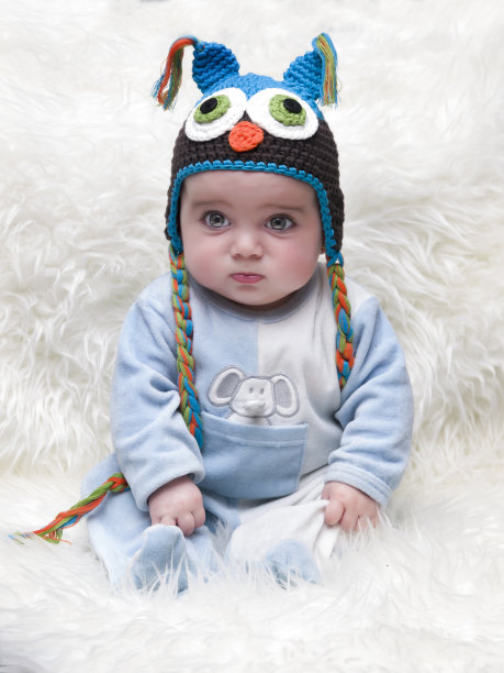 可爱的5个月的婴儿坐在高毛绒地毯上图片下载