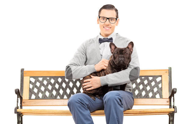 一个年轻人和他的狗坐在长凳上图片下载