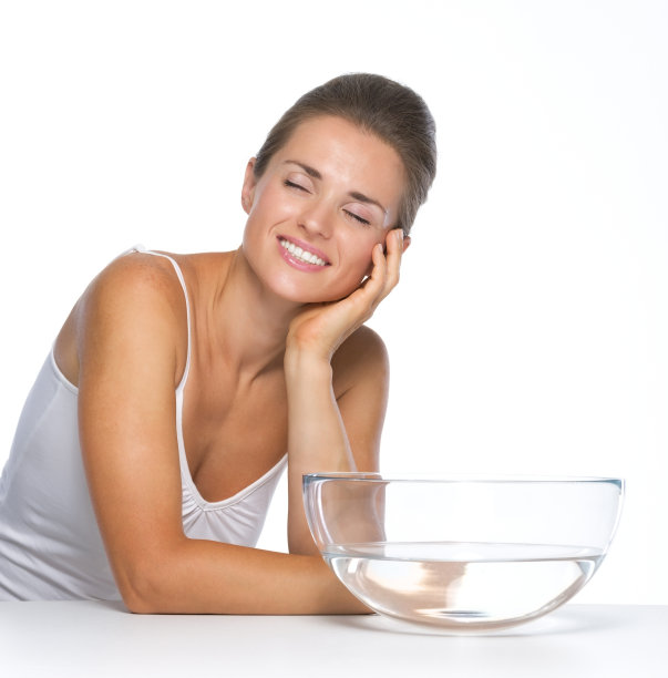 快乐的年轻女子和玻璃碗里的水图片下载