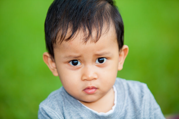 靠近可爱的亚洲孩子在绿色公园图片下载