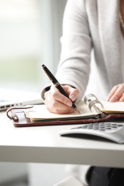 女商人在笔记本上记笔记。图片下载