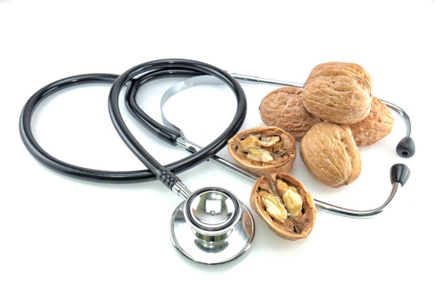 少量核桃和听诊器隔离在白色背图片下载