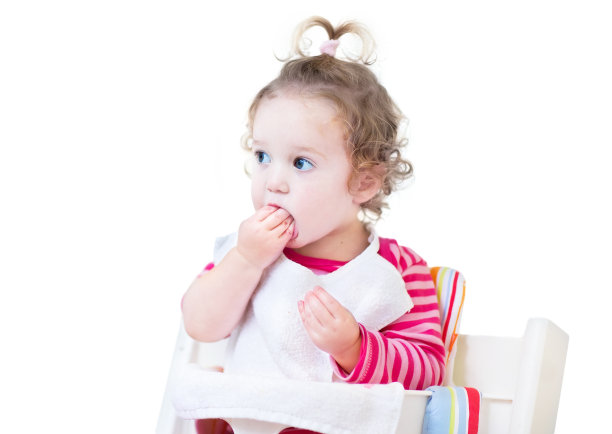 有趣的小女孩在白色高椅子上吃午饭图片下载