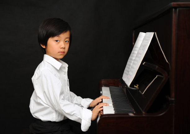 年轻的亚洲男孩在弹钢琴图片下载