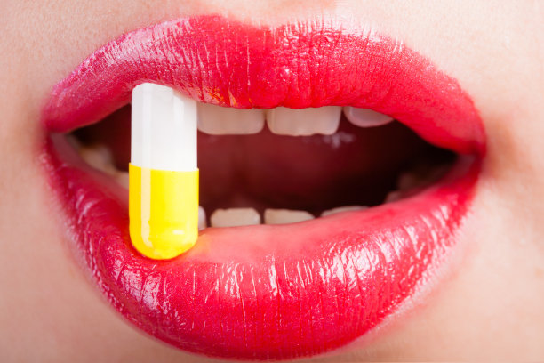 女人的嘴里有药丸。图片下载