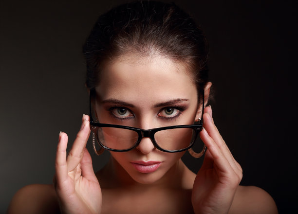 性感的化妆女人在时尚的眼镜看起来很热。特写肖像图片下载