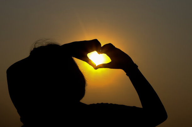 夕阳下，双手形成心形图片下载