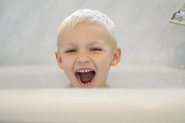 金发男孩在浴缸里笑图片下载