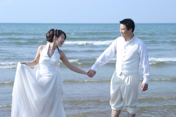 新娘和新郎在海滩边散步图片下载