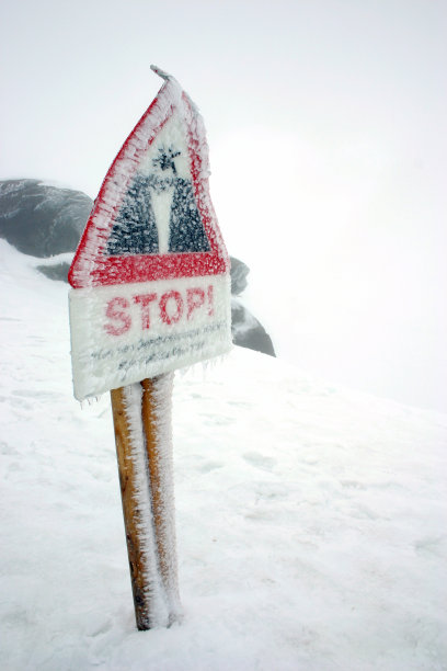 被雪覆盖的悬崖上的危险标志图片下载