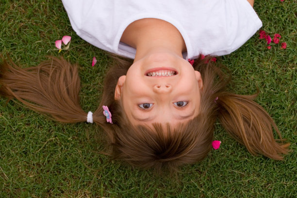 快乐的女孩躺在草坪上图片下载