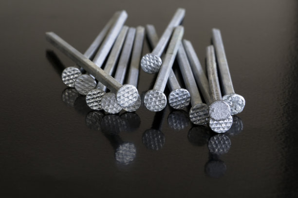 铁钉躺在黑色的钢制工作台上图片下载