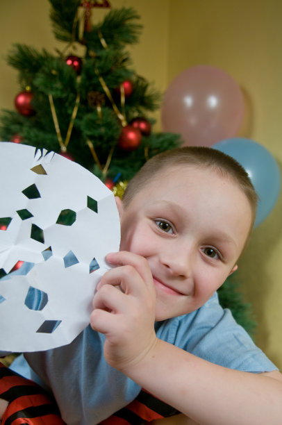 男孩剪下一片雪花图片下载