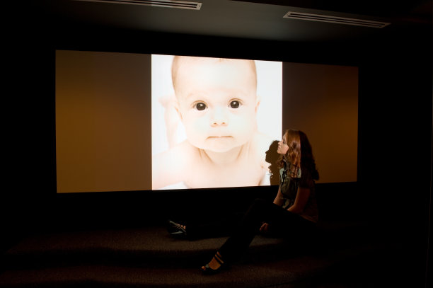 妇女放映婴儿照片在家庭影院图片下载
