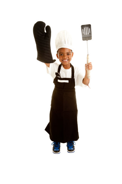 非裔美国小男孩扮演拿着烧烤用具的厨师图片下载