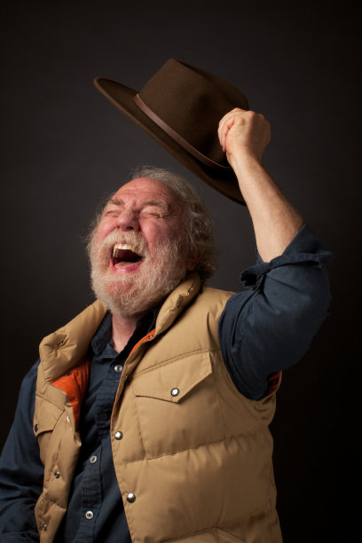 快乐的老人在空中挥舞着他的帽子图片下载