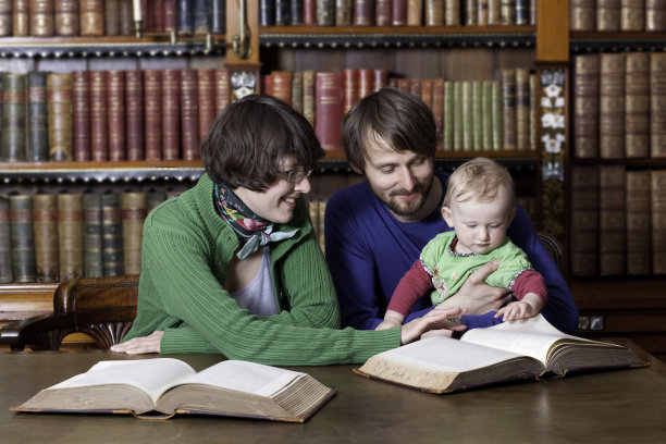 幸福的家庭和一个在古典图书馆阅读的孩子图片下载